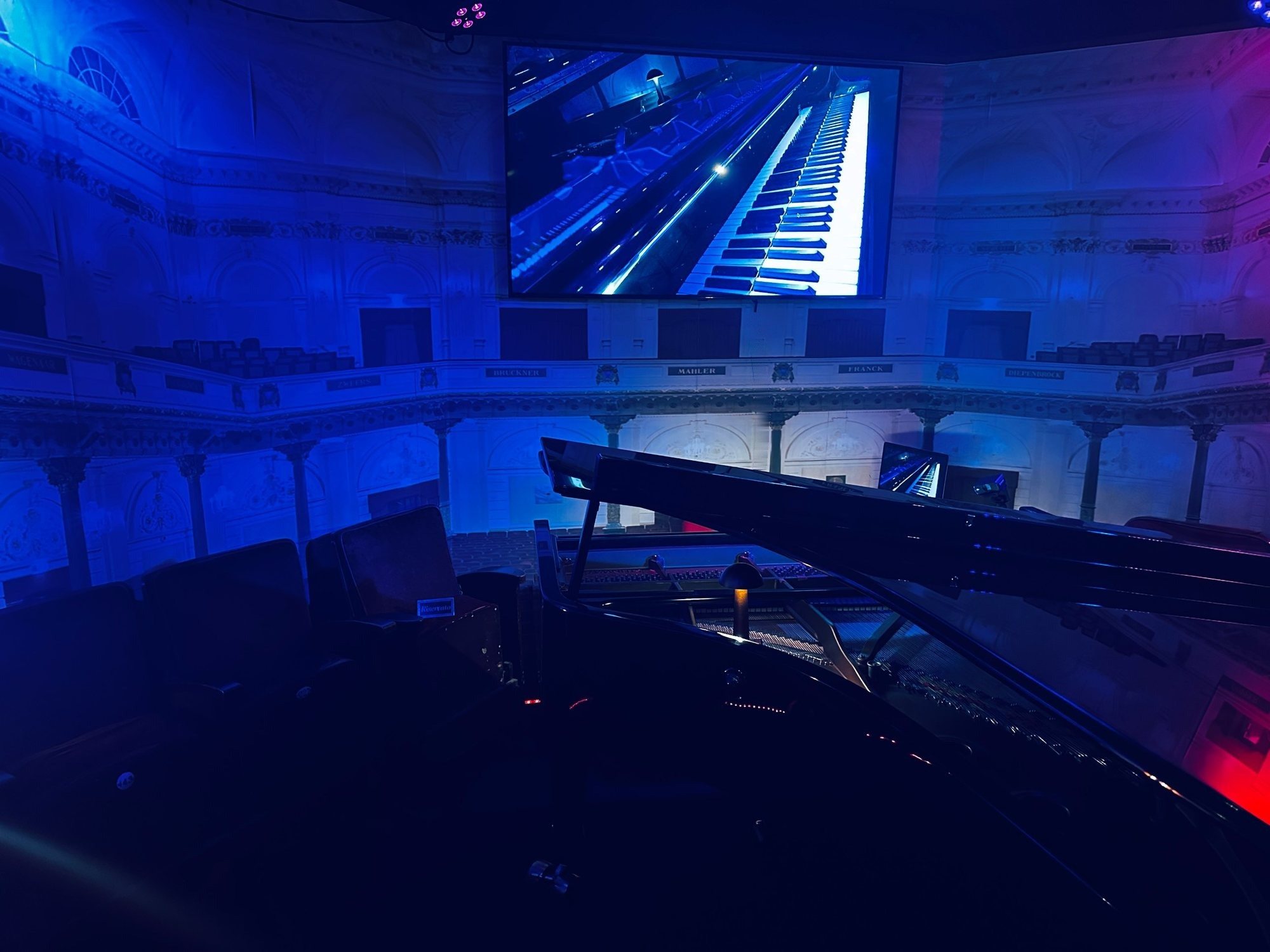 The room in blue light, seen from behind the concert grand